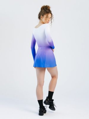A back-view studio shot of a model wearing a custom team skort, highlighting the clean A-line silhouette and a vibrant purple-to-blue ombre gradient that matches the long-sleeve dance body.