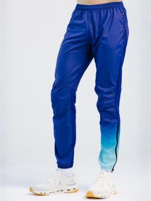A studio shot of professional custom teamwear training pants for women, featuring a vibrant blue-to-purple sublimation gradient on the lower leg and an elastic waistband, designed for high-performance comfort and durability.