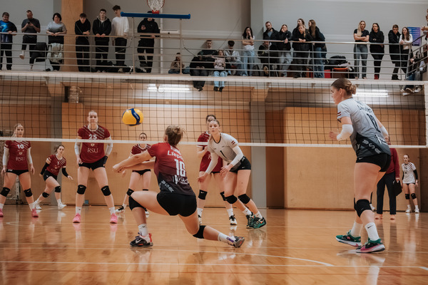 Female volleyball players competing in custom sublimation uniforms during a professional match.
