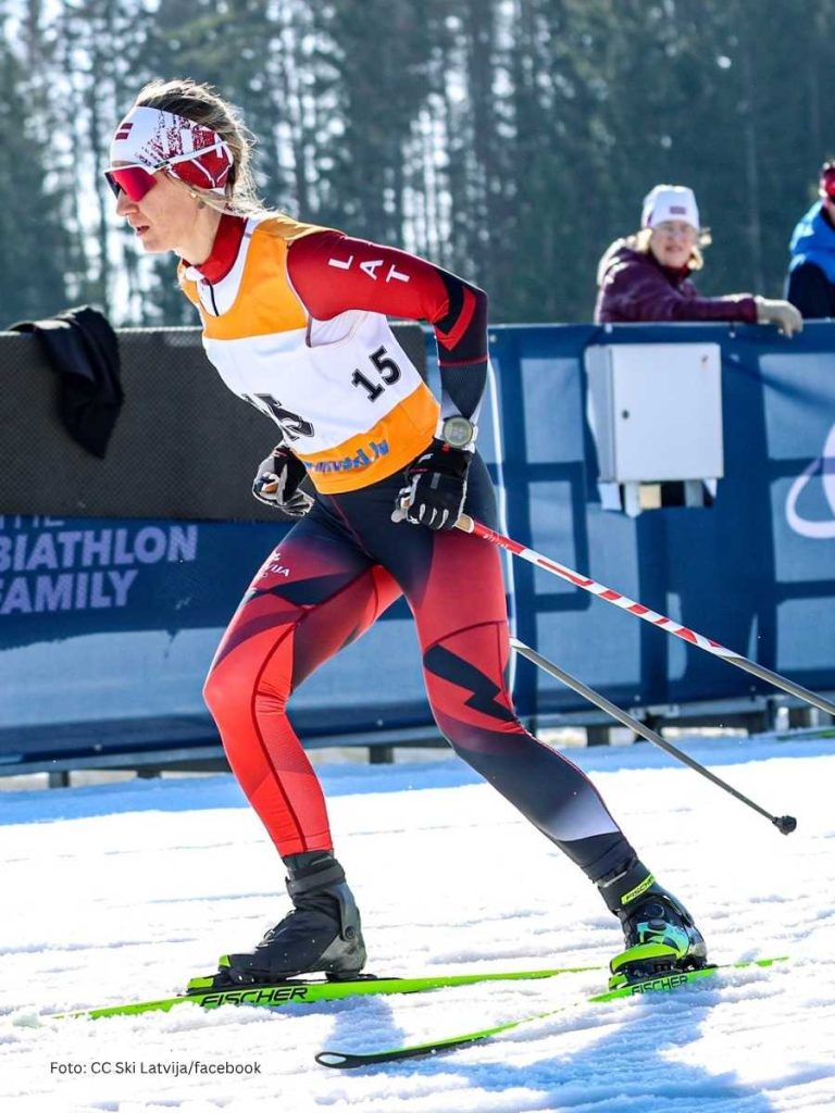 A female cross country skier wearing custom sportswear designed with high quality sublimation print during a winter race.